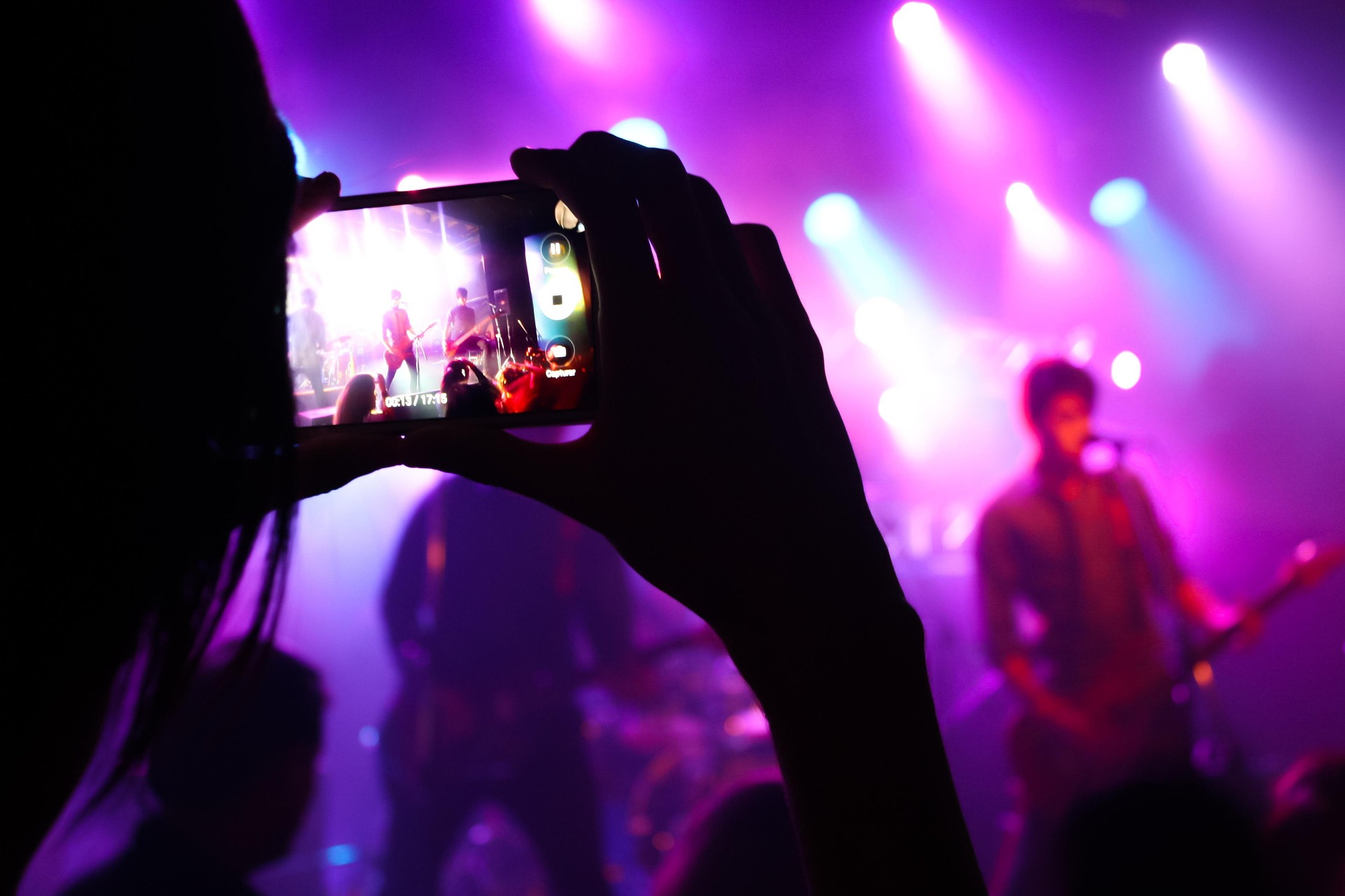 Musician playing guitar on stage at a concert